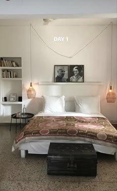 a bedroom with a large bed and two pictures on the wall above it's headboard