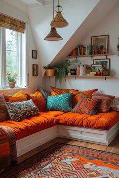 an orange couch sitting under a window in a living room next to a large rug