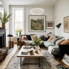 a living room filled with lots of furniture and paintings on the wall above it's fireplace