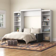 a bedroom with a bed, bookcases and a suitcase on the floor in front of it