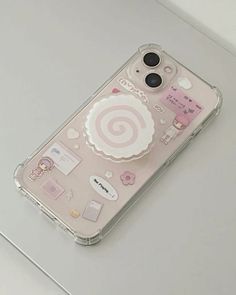 an iphone case with stickers on it sitting on top of a white countertop