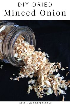 a jar filled with shredded onions sitting on top of a black table next to a spoon