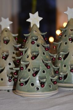 three ceramic christmas trees on a table