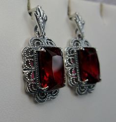 Simulated Red Ruby Solid Sterling Silver Earrings Short Festoon Design#E8z (shorter version) These Victorian reproduction estate earrings are solid sterling silver. These filigree earrings have stunning simulated red ruby gemstones. Each stunning gem is 10mm x 8mm x 5mm in dimension. The earrings are approximately 1/2" x 1" (13mm x 23mm). The unique earrings are marked 925 for solid sterling silver. These lovely earrings were refashioned from an antique Victorian cameo necklace. Quintessentially Red Jewelry Set, Jeweled Flowers, Armenian Jewelry, Red Stone Ring, Marcasite Jewelry, Filigree Jewelry, Mid Century Jewelry, Red Jewelry, Filigree Earrings