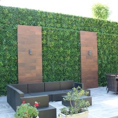 an outdoor living area with couches, tables and privacy screens on the side wall