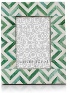 a green and white photo frame with an ornate pattern on the bottom, in front of a