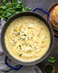 a bowl of soup with bread and parsley on the side