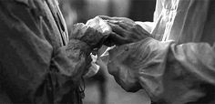 two people standing next to each other in raincoats and holding hands with one another