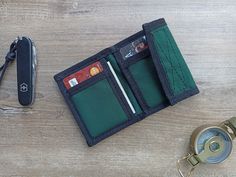 "This is a small, lightweight Cordura wallet. Made to order from 1000D Cordura. The wallet has two horizontal side pockets for bills and cards and one more vertical pocket on both sides for cards. The left and right horizontal pockets can store folded bills or up to 5 credit cards (in each pocket). The external vertical pockets can store about 3 credit cards. Closed size:  Width - 3 1/8\" (8 cm) Height - 4 1/8\" (10,5 cm) Open size: Width - 8 4/8\" (21,5 cm) Height - 4 1/8\" (10,5 cm) It closes Functional Rectangular Wallet For Gift, Green Trifold Wallet With Coin Pocket For Everyday Use, Functional Green Rectangular Wallet, Durable Bifold Wallet For Everyday Use, Durable Practical Wallets For Everyday Use, Durable Practical Wallets, Durable Everyday Practical Wallets, Green Trifold Wallet For Everyday Use, Minimalist Wallet