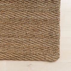 a close up view of a rug on the floor with white wood floors in the background