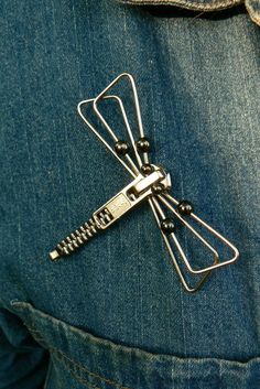 a person wearing blue jeans has a metal hair clip attached to their back