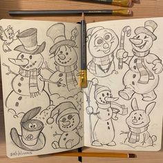 an open notebook with drawings of snowmen on it and pencils next to it