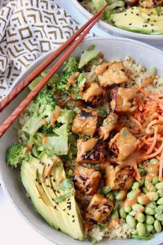 two bowls filled with food and chopsticks next to each other