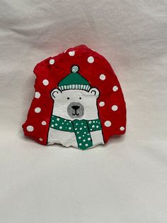 a white bear wearing a green hat and scarf with polka dots on it's face