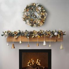 a fireplace decorated with christmas decorations and bells