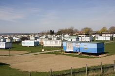 several blue and white trailer homes in a field