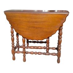 an old wooden table with two legs and a bowl on it's top, against a white background