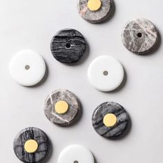 marble buttons are arranged on a white surface, with yellow and black dots in the middle