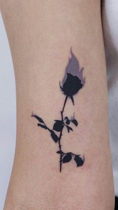 a black and white rose tattoo on the left arm