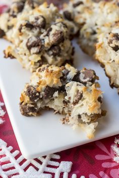 a white plate topped with cookies and chocolates on top of a red table cloth