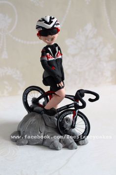 a small figurine of a boy riding a bike on top of an elephant