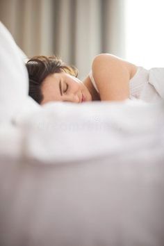 a woman laying in bed with her eyes closed