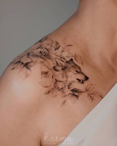 a woman's chest with flowers and a wolf on it