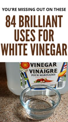 a bottle of vinegar sitting on top of a counter next to a glass bowl filled with liquid