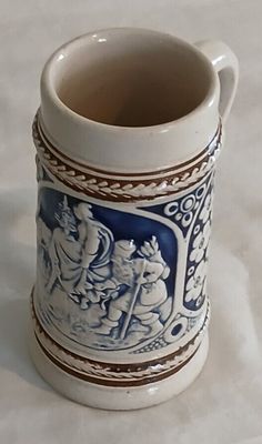 a blue and white mug with an image of people on it