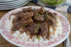 a white plate topped with meat and rice