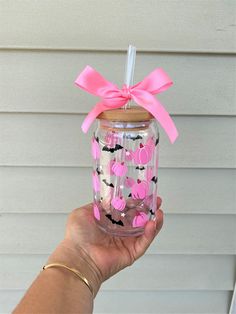 a person holding up a pink and black cup