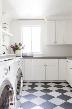 a washer and dryer in a kitchen with black and white checkered floor