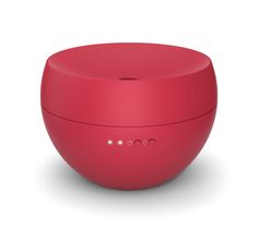 a red speaker sitting on top of a white surface