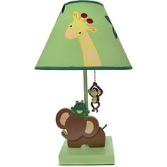 a green lamp with a giraffe and monkey on it's face next to a light shade