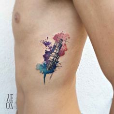 a woman's stomach with a watercolor tattoo on it