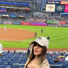 a woman standing in front of a baseball field