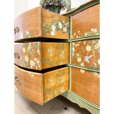 the drawers are painted with flowers and leaves