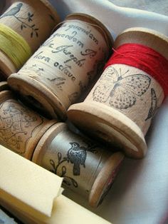 several spools of thread sitting on top of each other in a wooden box