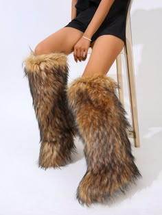 a woman is sitting on a chair with furry boots in front of her legs and feet