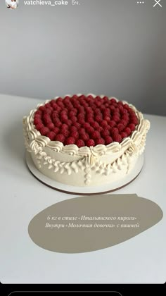 a cake with raspberries on it sitting on top of a white countertop