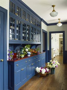 a kitchen with blue cabinets and flowers on the counter