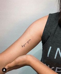 a woman's arm with a small tattoo saying love is in the air on it