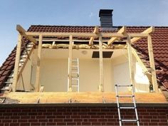 a ladder is on the roof of a house being built with brick and shingles