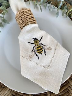 a white plate topped with a napkin covered in a bee