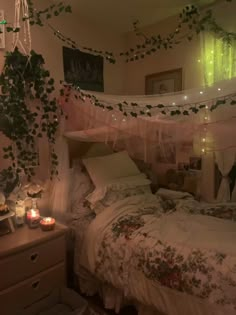 a bedroom with an unmade bed and lots of greenery hanging from the ceiling