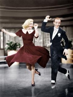 a man and woman are dancing together in an old fashion dance studio, wearing formal clothes