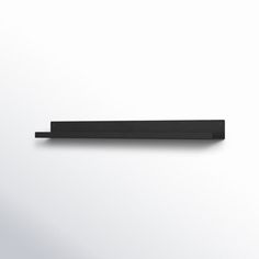 a black shelf sitting on top of a white wall