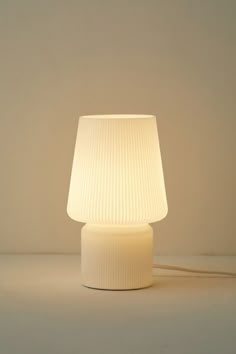 a white lamp sitting on top of a table