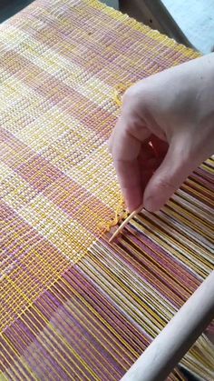 someone is working on weaving with their hand