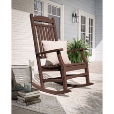 a wooden rocking chair sitting on top of a patio next to a potted plant